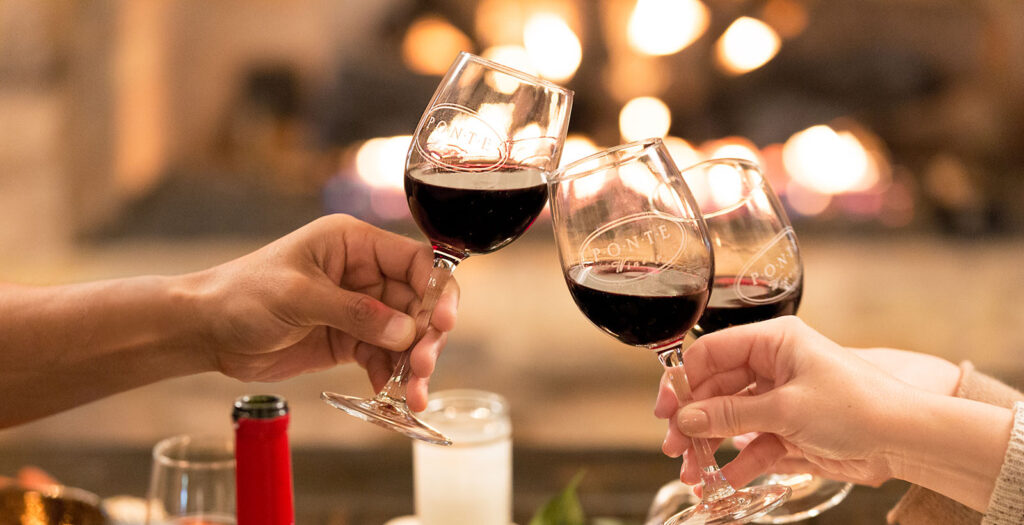 Three wine glasses clinking