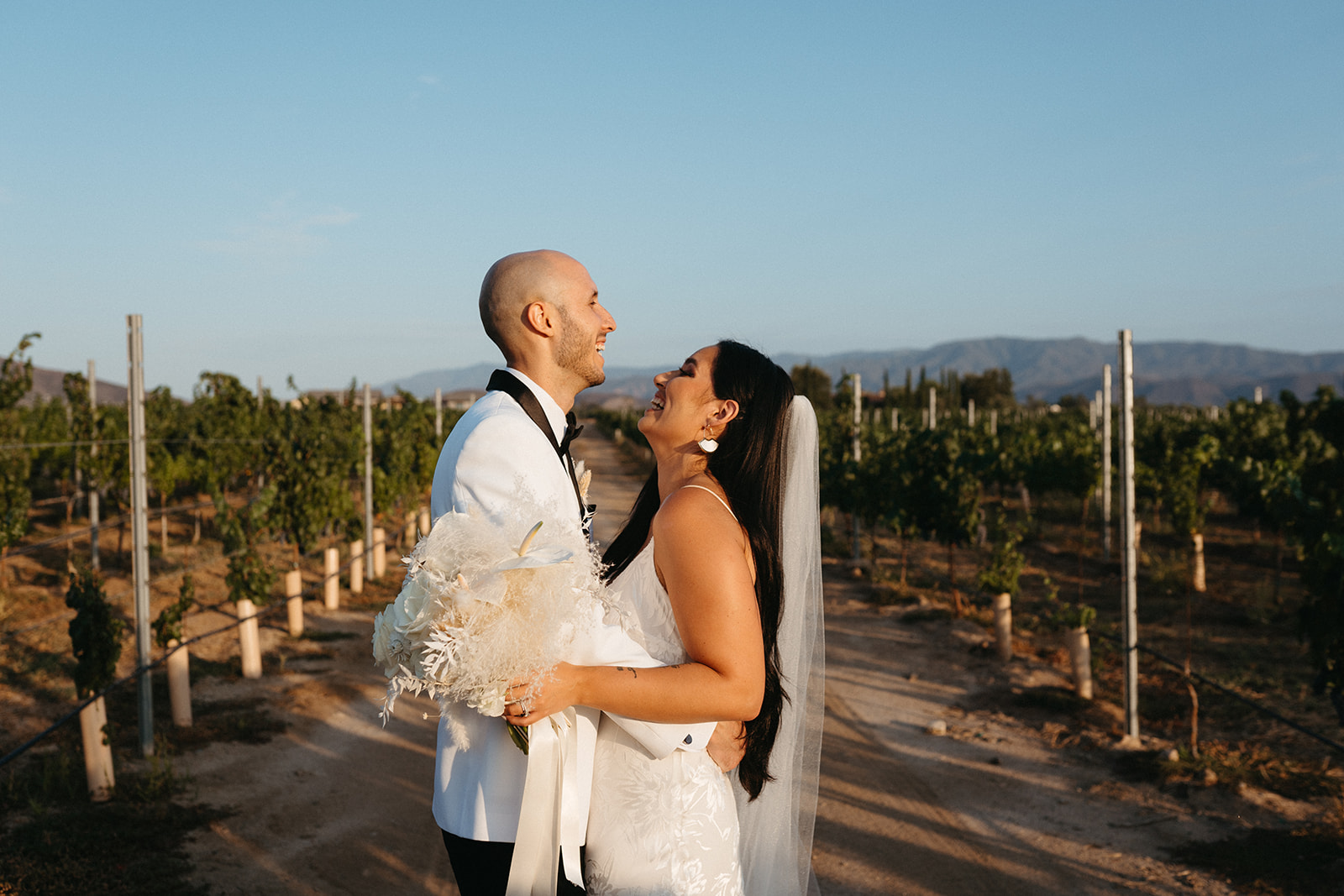 wedding couple laughing in the vineyards