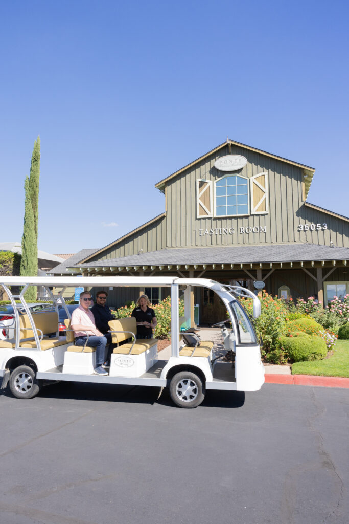 The bus vineyard tour posing for a photo in front of the Ponte Winery Tasting Room building